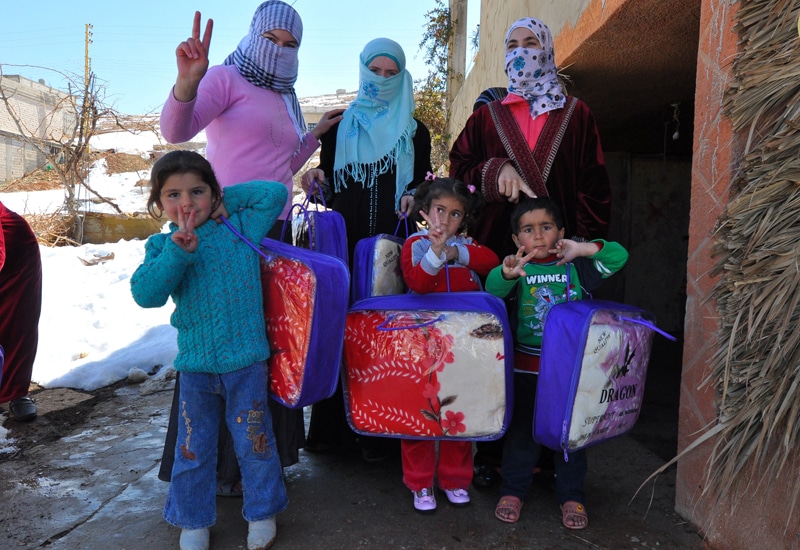 Syrian women and children giving peace sign